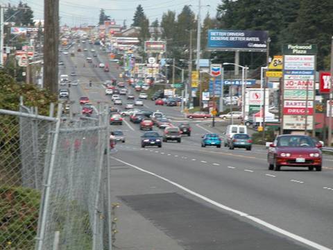 Figure 99.  SR 99 before reconstruction in SeaTac (top) and Shoreline (bottom).  Note the wide paved shoulders, lack of access control, and no sidewalks.  One of the primary goals of the communities along the highway was to create a more attractive, pedestrian-friendly local environment.