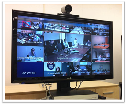 Photograph of a monitor displaying the live feed from the ten States, the Resource Center, and Office of Safety during the Peer to Peer event. There is a video camera mounted on the monitor.