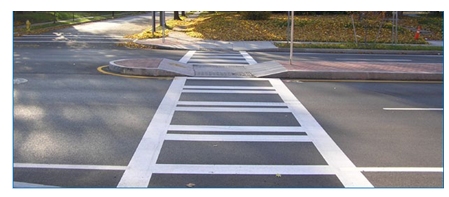 Photo of a crosswalk in a suburban neighborhood that uses a channelized median as a pedestrian refuge