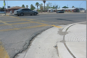 Figure 14: Asphalt pushed up against curb ramp. Photo by Tom Fisher