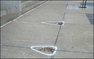 Missing areas of concrete have been marked for repair.