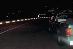 Photo.  Photo is of linear reflectorization effect of reflective sheeting placement on guardrails.  These are night photos and show a high degree of visibility of the curves due to this application