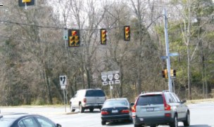 Photo of vehicles turning left at a signalized intersection.