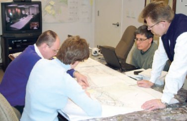 Photo of an RSA team in an office going over road maps and designs.