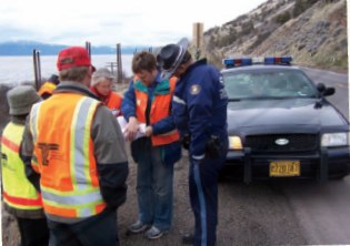 Photo of an RSA team assessing a winding road above the ocean with local police.