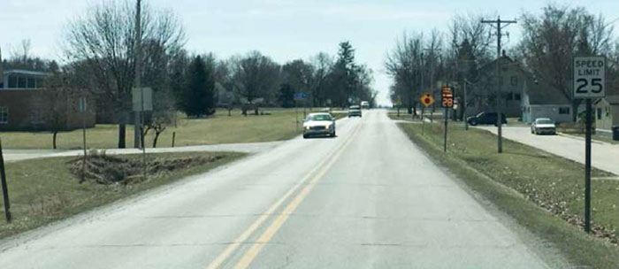 Figure 5-9 Speed feedback sign in Slater, IA (Image Source: Neal Hawkins) St. Charles. This photo shows a speed feedback sign reading 28 MPH on a residential road with cars, also near a sign that reads 25 Speed Limit.