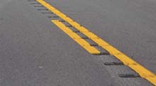 Photo of rumble strips along yellow striping on roadway.