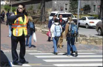 Photo: Crossing guard assisting children in the cosswalk