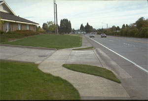 Sidewalk that curves up to meet driveway at a level area