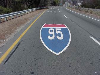 Figure 18. Photo. Route shield pavement marking in Virginia. This photo shows pavement markings within the lane of travel. The first marking shows the I-95 shield; subsequent lane markings in the direction of travel say 'This,' 'Lane,' and 'Only.'
