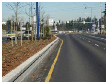 A raised median separates traffic traveling in opposing directions on a four-lane roadway.