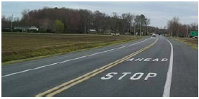 Roadway with 'Stop Ahead' marked in advance of an intersection.