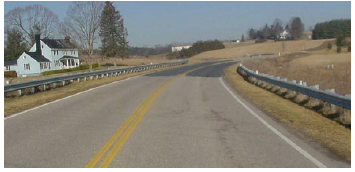 A road with a curve in which the elevation just prior to the curve begins to increase.
