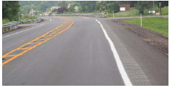 A curving roadway with narrowed lanes and edgeline rumble strips.