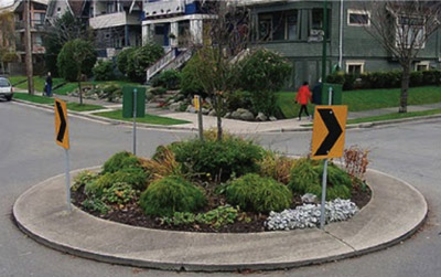 Photo. A traffic circle with a landscaped circle in the center.