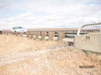 Photo. This photo shows a traditional transition from a guardrail to a bridge parapet.