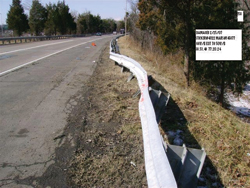 Photo. This photo shows a guardrail which is bent out of line by more than 18 inches.