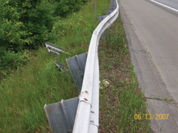 Photo. This photo shows a guardrail which is bent less than 12 inches out of line.