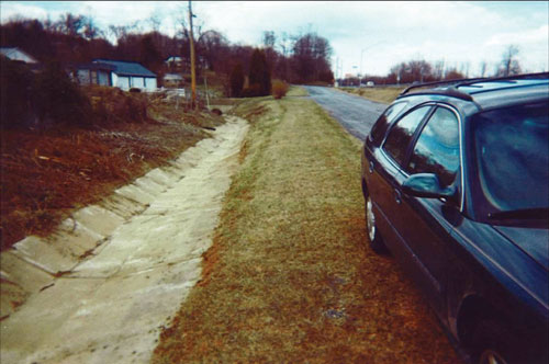 Photo. This photo shows a drainage ditch lined with concrete. 