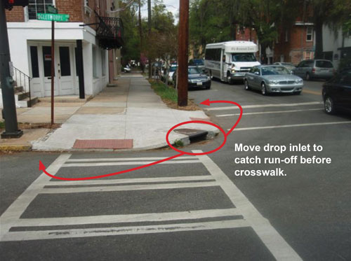 Photo. This photo shows an improperly placed drainage grate on a street corner.