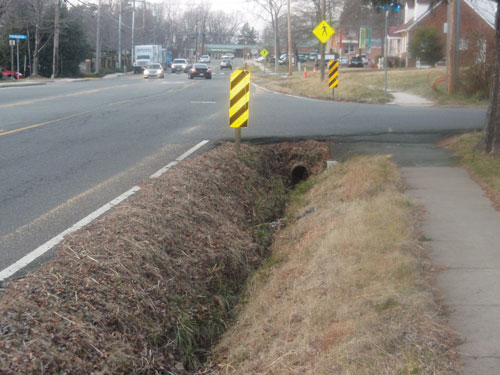 Photo. This photo shows a grassy, v-shaped drainage ditch which is considered non-traversable and a safety hazard.