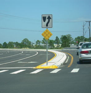 The second photo depicts a sign with an object marker on its post on a median.
