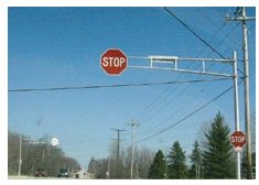 Photo of an oversize Stop sign mounted to an overhead gantry.