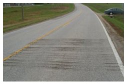 Photo of a rural roadway with rumble strips cut into one of the travel lanes.