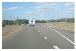 Photo of a rural roadway with both left and right turn lanes.