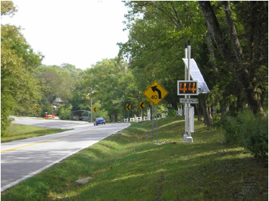 Solar powered speed feedback sign on a sharply curving rural road in Missouri.