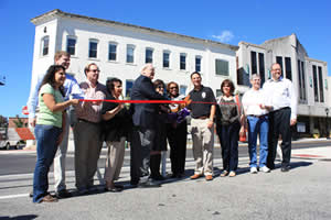 Photo: Group of town officials and citizens at a ribbon-cutting event on a local street.