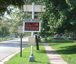 This is a photo of an automatic speed warning sign showing SLOW DOWN in a neighborhood area.