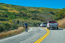 This is a photo showing a bicyclist on a two-lane rural road.