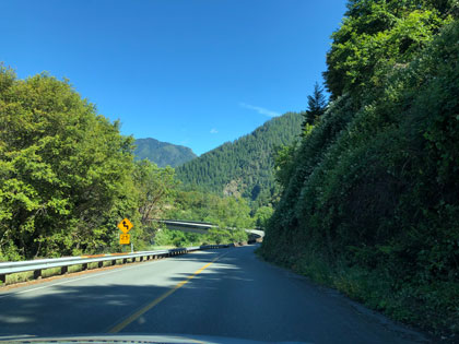 This is a photo of a rural road going through a mountainous area with a number of curves.