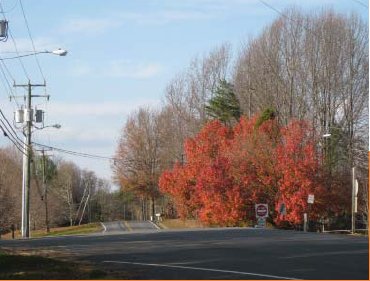 Photo of a rural roadway where the road topography prevents drivers approaching an intersection from opposite directionsto see each other clearly.