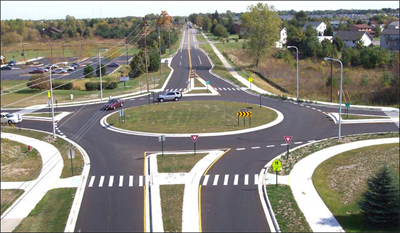 Photo. A four way roundabout intersection.