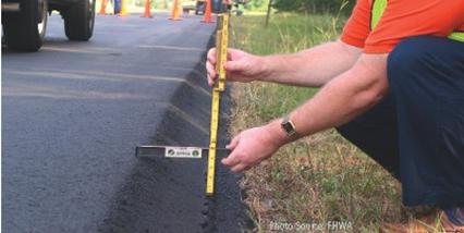 Image: A man measuring the angle and depth of a pavement edge dropoff. Source: FHWA