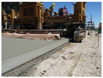 Photo of a machine applying the Safety Edge to newly laid pavement.