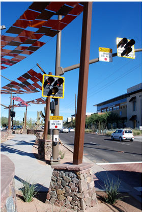 A post-mounted high-intensity crosswalk beacon designed for a mid-block pedestrian crosswalk in an urban area.