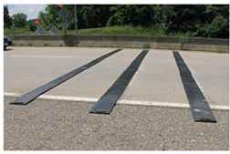Temporary rumble strips spanning a two-lane roadway.