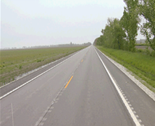 A rural roadway featuring edgeline and centerline striping.