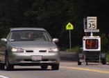 Vehicle passing a speed feedback sign.