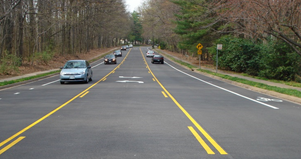 Photo of a Road Diet on Soapstone Road. As with Lawyers Road, this installation features two through lanes, a center two-way left-turn lane, and dedicated bike lanes.