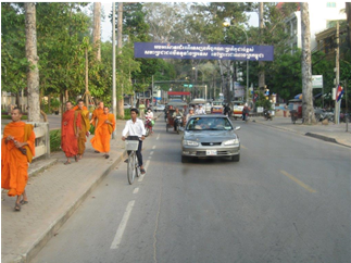 A two-lane roadway in a developing country with paved sidewalks and a dedicated bike lane.