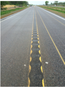 A roadway in which a 14-inch wide mumble strip with a 16-inch wavelength has been installed.