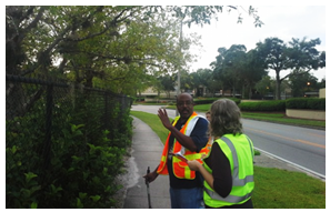 Members of the audit team discussing a thick stand of vegetation on a curve that may inhibit line of sight for turning traffic.