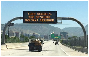 Gantry over a freeway reads &quot;Turn Signals, the original instant message.&quot;