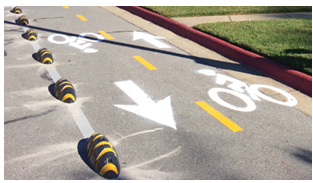 "Armadillos" are used to separate travel lanes from a bike lane for the Downtown Trail in Bentonville's Public Library parking lot.