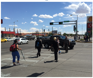 A mix of turning vehicles and pedestrians attempting to traverse a busy intersection illustrates the potential for dangerous pedestrian-vehicle conflicts.