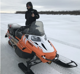 Orutsararmiut Native Council Search and Rescue member Charles Guest uses his snowmobile to monitor ice road conditions.